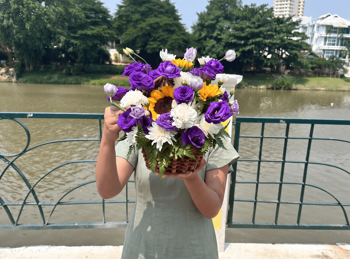 Flower basket with purple lisianthus, sunflowers, white carnations, and white chrysanthemums arranged in a woven basket with fresh greenery. The strong contrast between deep purple and bright yellow makes this basket suitable for birthday gifts, congratulations, thank you flowers, and flower basket delivery in Chiang Mai.
Size: width 30cm, height 30cm
