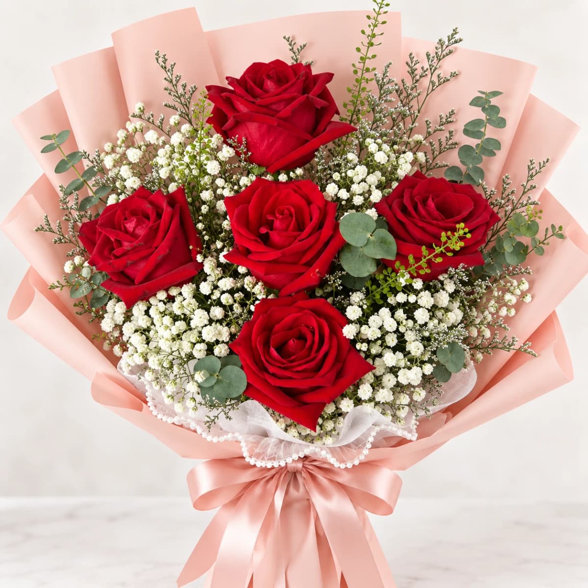 Elegant red rose bouquet wrapped in pink paper for special occasions.