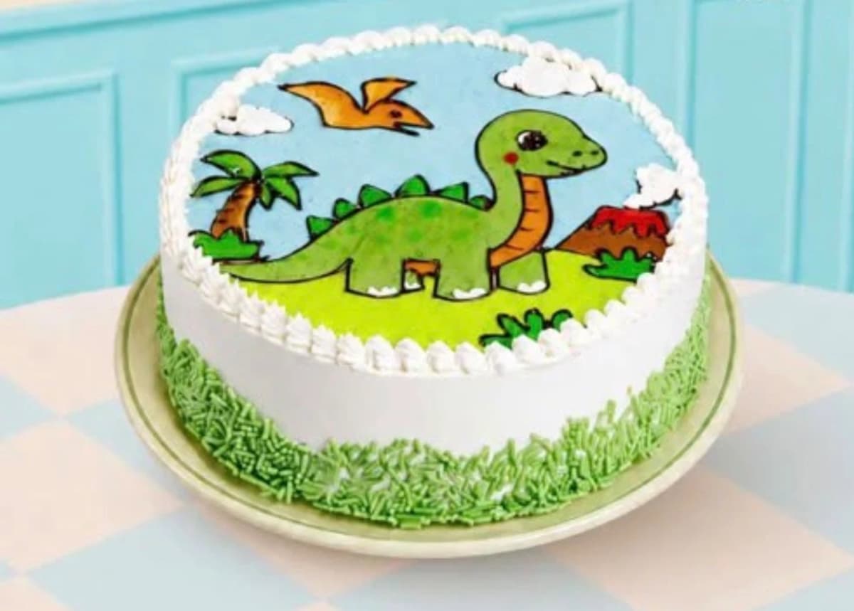 Dinosaur-themed birthday cake with green icing and sprinkles.