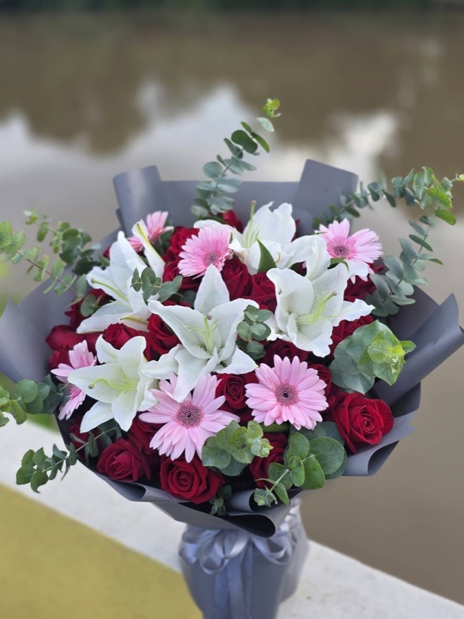 Mixed bouquet with pink gerberas and roses wrapped for a compact get-well gift